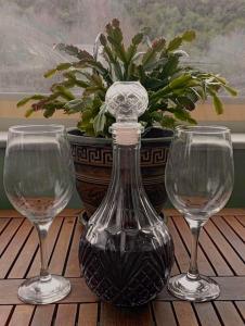 two wine glasses and a vase on a table at Lil' fam farm home - Beach 10min in Agios Ioannis