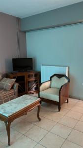 a living room with a couch and a chair and a table at Kanalis Houses in Avlonárion