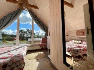 sypialnia z łóżkiem i dużym oknem w obiekcie Halo Dębki w Dębkach