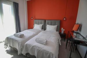 two twin beds in a room with orange walls at LA CASA DE PROFESOR 2 in Kalabaka