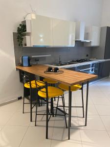 Una cocina con una mesa de madera y sillas amarillas. en Casa Margherita - locazione turistica, en Polignano a Mare 13 fotos más