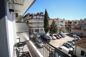 an apartment balcony with cars parked in a parking lot at LA CASA DE PROFESOR 2 in Kalabaka