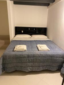 ポリニャーノ・ア・マーレにあるCasa Margherita Stefy - locazione turisticaのベッドルーム1室(ベッド1台、タオル2枚付)