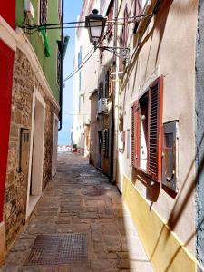 a narrow alley with a building and a street light at Terra Apartments in Piran