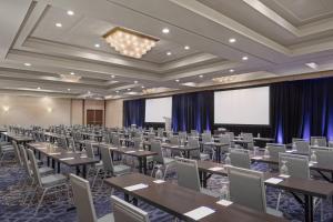 a conference room with tables and chairs and a projection screen at Delta Hotel Philadelphia Airport in Philadelphia