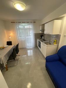 eine Küche mit einem Tisch und einem blauen Sofa in der Unterkunft Riviera in Rijeka