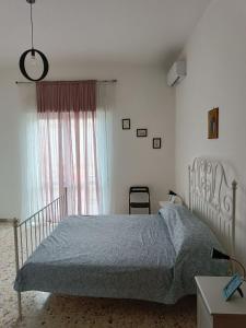 a bedroom with a bed and a window at Villa Carmela Capotosto in Mondragone