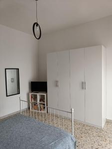 a bedroom with white cabinets and a bed and a mirror at Villa Carmela Capotosto in Mondragone