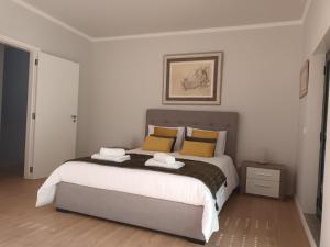 a bedroom with a large bed with yellow pillows at Casa do Lameirinho in Angra do Heroísmo