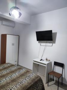 a bedroom with a bed and a desk and a tv at Bed and Breakfast Oasi in Reggio di Calabria