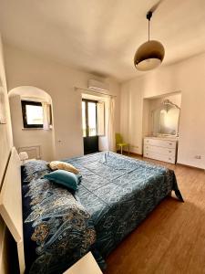 um quarto com uma cama grande e um cobertor azul em Maiolica House em Cefalù