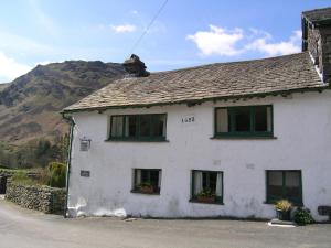 a white house with windows and a mountain at 2 Town Head Cottages in Grasmere