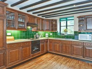 Rosedale AbbeyにあるThe Coach Houseの木製のキャビネットと緑のタイルが備わる広いキッチン