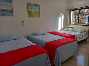 a bedroom with two beds and a window at Ap 2 quartos suite wifi 30m da praia in Guarujá