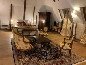 a bedroom with a bed and two chairs and a table at La Réserve de Rilhat in Cognat-Lyonne