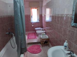 a bathroom with a sink and a tub and a toilet at Bed and Breakfast Oasi in Reggio di Calabria