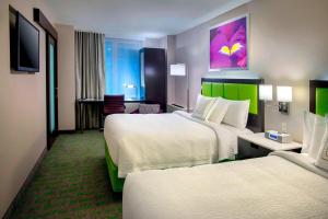 ein Hotelzimmer mit 2 Betten und einem TV in der Unterkunft SpringHill Suites by Marriott New York Midtown Manhattan/Fifth Avenue in New York