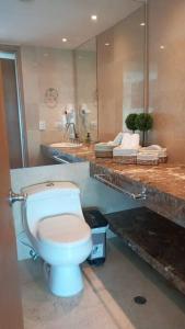 y baño con aseo blanco y lavamanos. en Luxury apartment in Morros - Cartagena de Indias en Cartagena de Indias