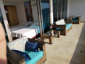 a hotel room with a balcony with chairs and a couch at Luxury apartment in Morros - Cartagena de Indias in Cartagena de Indias