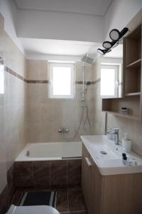 a bathroom with a tub and a toilet and a sink at Athens & Acropolis View 7th Floor Apartment in Athens