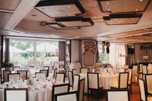 una sala de banquetes con mesas y sillas blancas en Landhotel Altmann en Hörstel