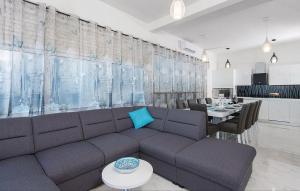 Una sala de estar con un sofá y un comedor. en Apartment ARGO on the beach, en Sreser