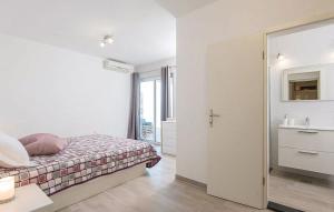 Un dormitorio blanco con una cama y un baño. en Apartment ARGO on the beach, en Sreser