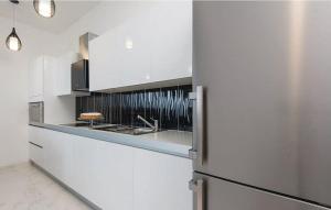 Una cocina con gabinetes blancos y un refrigerador de acero inoxidable. en Apartment ARGO on the beach, en Sreser 31 fotos más
