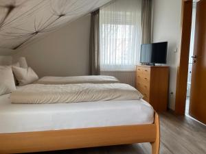 a bedroom with a bed and a flat screen tv at Landhotel Altmann in Hörstel