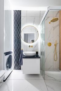 bagno con lavandino e specchio di Apartmenteight a Toruń