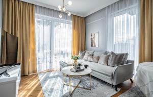 un soggiorno con divano e tavolo di Apartmenteight a Toruń