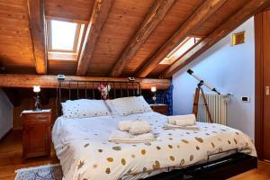 a bedroom with a large bed in a room with wooden ceilings at B&B Adelche in San Giovanni Bianco