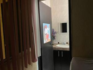 ein Badezimmer mit einem Waschbecken und einer Badezimmertür mit einem Bild in der Unterkunft Great place to chill! in Zihuatanejo