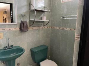 een badkamer met een groen toilet en een wastafel bij Great place to chill! in Zihuatanejo