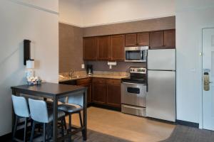 uma cozinha com utensílios de aço inoxidável e armários de madeira em Residence Inn Silver Spring em Silver Spring