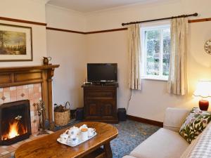 a living room with a fireplace and a tv at Greystones in Kilnsey