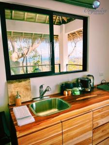fregadero de cocina con un espejo grande encima en Organica Yoga Shelter en Paquera