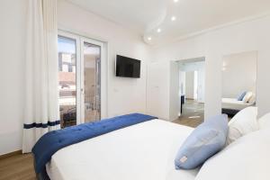 um quarto branco com uma cama grande e uma janela em YourHome - Lidia Rooms & Suites em Sorrento