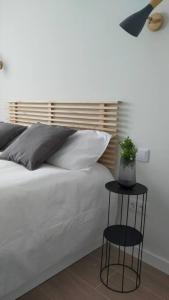 sypialnia z białym łóżkiem i rośliną na stole w obiekcie Apartamento Laurana w mieście Santander