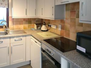 a kitchen with white cabinets and a tea kettle at Pheasant in Welney