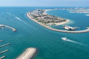 una vista aérea de una playa con un barco en el agua en Vogue Fascinating Beachfront One Bedroom Apartment with Balcony and Palm Views & Private Beach with full Amenities, en Dubái