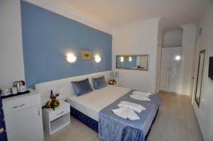 a blue bedroom with a bed with towels on it at Navy Hotel in Marmaris +53 photos