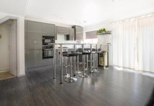 a kitchen with a counter and stools in a room at Perfect couple retreat to unwind&relax with HotTub in Peacehaven