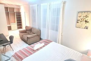1 dormitorio con 1 cama, 1 silla y 1 sofá en Habitación amplia con baño privado a pasos de la playa en piso familiar, en San Sebastián