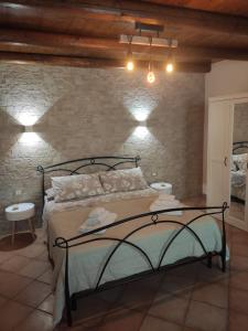 Un dormitorio con una cama y una pared de piedra. en Casa Ciuri Ciuri, en Noto