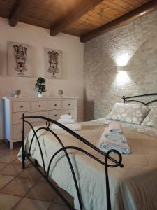 Un dormitorio con una cama y una pared de piedra. en Casa Ciuri Ciuri, en Noto
