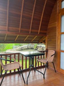 a patio with a table and two chairs on a deck at Vila Kopi Ciwidey in Ciwidey