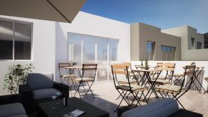 a patio with chairs and a table on a balcony at Gest in Mellieħa