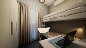 a bedroom with a bed with a laptop computer on a desk at Gest in Mellieħa