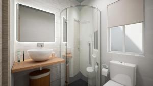 a white bathroom with a sink and a toilet at Gest in Mellieħa